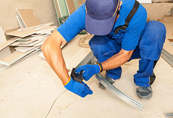 A repairman replacing parts on garage doors